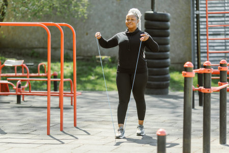 Afro-american plus size woman doing workout exercises session outdoor