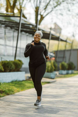 Afro-american plus size woman jogging outdoorの写真素材
