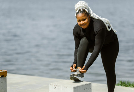 Afro-american plus size woman doing workout exercises session outdoor