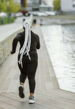 Afro-american plus size woman jogging outdoorの写真素材