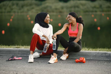 Two black women holding a bottles with water after doing workoutの写真素材