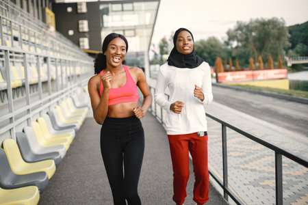 Two black women running on a stadiumの写真素材