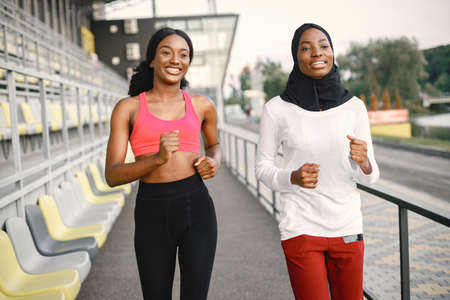 Two black women running on a stadiumの写真素材