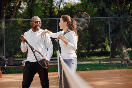 Black man talking with woman at tennis court