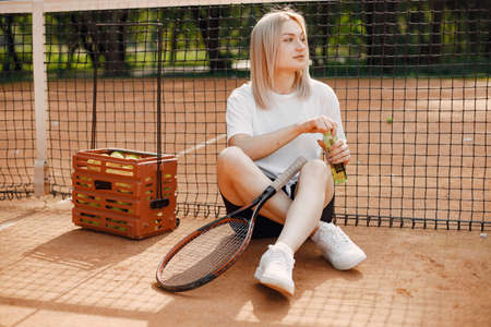 Young female tennis player relax after matchの写真素材