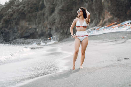 Girl in a stylish swimsuit have a rest n a beachの写真素材