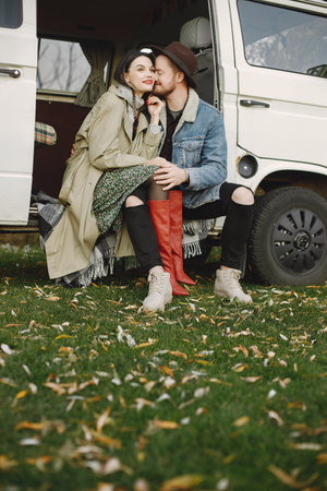 Stylish couple sitting in a retro bus and posing for a photoの写真素材