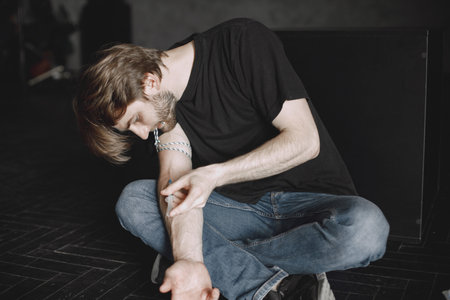 Drug addict injecting heroin into armの写真素材