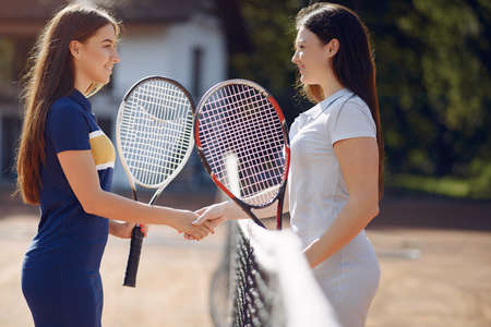 Two female tennis players shaking hands after the matchの写真素材