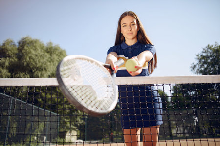 Caucasian female tennis player holding a racket and posing for a photo