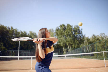 Caucasian female tennis player playing on the court outdoorsの写真素材