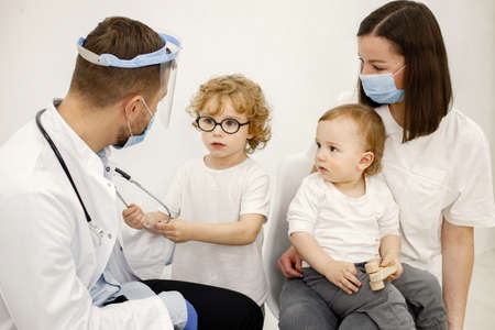 Mother and two her sons have an appointment with pediatricianの写真素材
