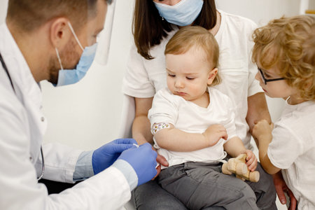 Male doctor stick a band to a boy after a vaccination