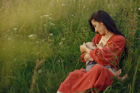 Woman sitting on a blanket and breastfeeding her little sonの写真素材