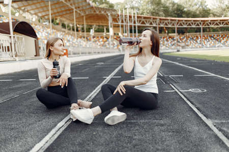 Sports girls in a uniform sitting at the stadiumの写真素材