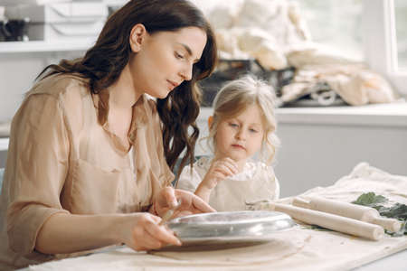 Portrait of mother and little girl shaping clay togetherの写真素材