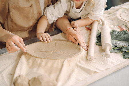 Portrait of mother and little girl shaping clay togetherの写真素材