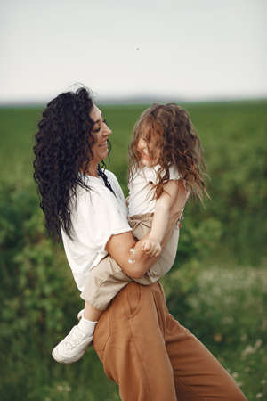 Mother with daughter playing in a summer fieldの写真素材