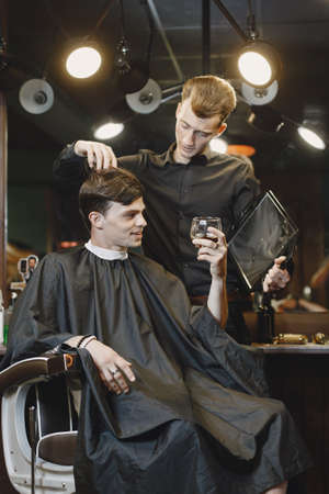 Stylish man sitting in a barbershopの写真素材