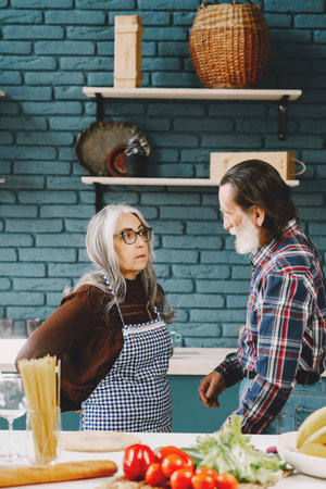 Senior couple putting on aprons before preparing food in kitchen