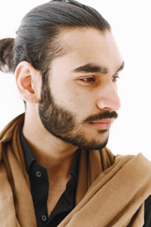 Young muslim man posing casually over white wall. Studio, isolated.