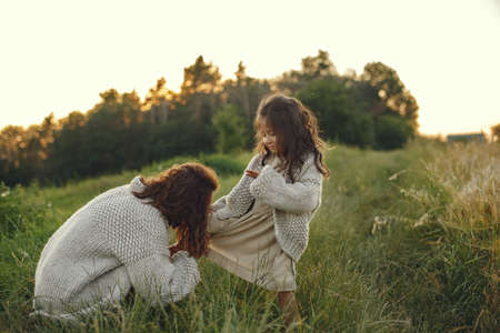 Mother with daughter playing in a summer fieldの写真素材