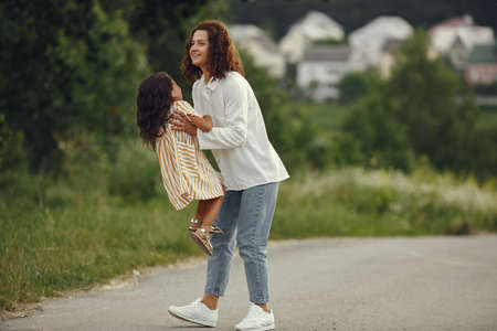 Mother with daughter playing in a summer fieldの写真素材