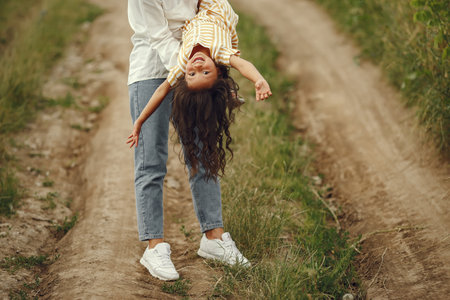Mother with daughter playing in a summer fieldの写真素材