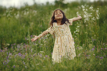 Cute little girl playing in a summer fieldの写真素材