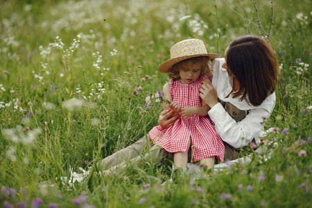 Mother with daughter playing in a summer field