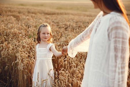 Mother with daughter playing in a summer fieldの写真素材