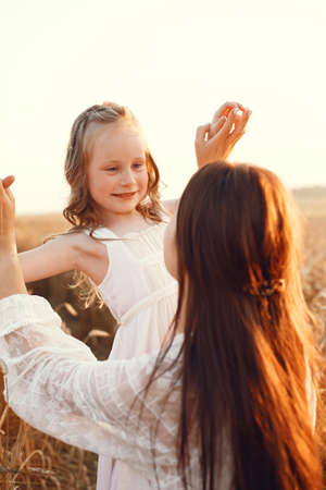 Mother with daughter playing in a summer fieldの写真素材