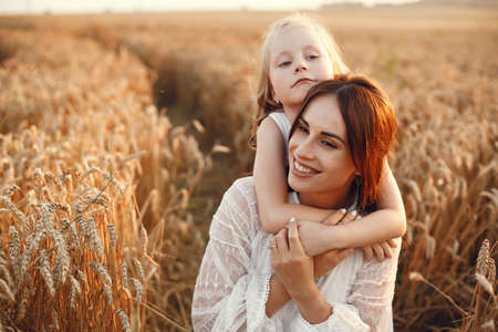 Mother with daughter playing in a summer fieldの写真素材