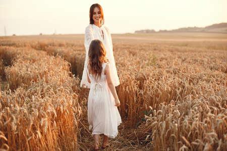 Mother with daughter playing in a summer fieldの写真素材