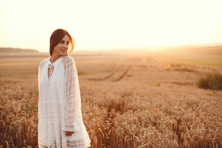 Beautiful elegant girl in a autumn wheat fieldの写真素材