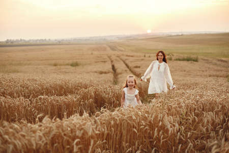 Mother with daughter playing in a summer fieldの写真素材