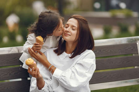 Mother with daughter eats ice cream in the cityの写真素材