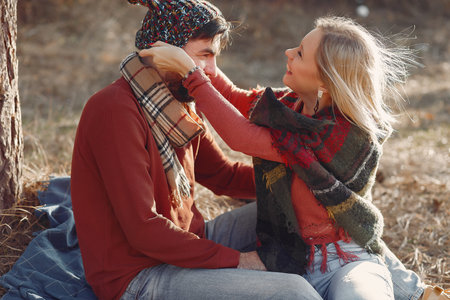 Couple sitting by the tree in a spring forestの写真素材