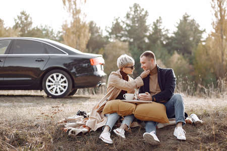 Beautiful couple spend time on a autumn fieldの写真素材