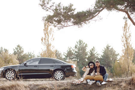 Beautiful couple spend time on a autumn fieldの写真素材