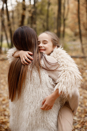 Portrair of mother and her daughter hugging outdoorsの写真素材