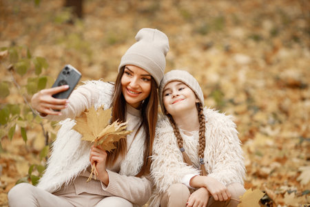 Mother and her daughter make a selfie in autumn forestの写真素材