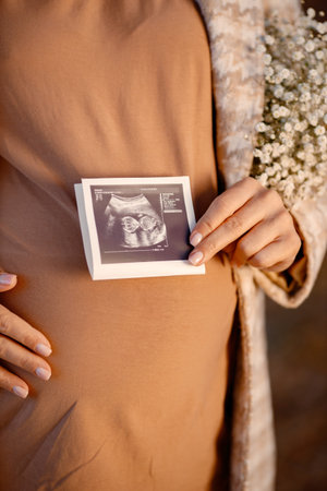 Midsection of pregnant woman standing at autumn park