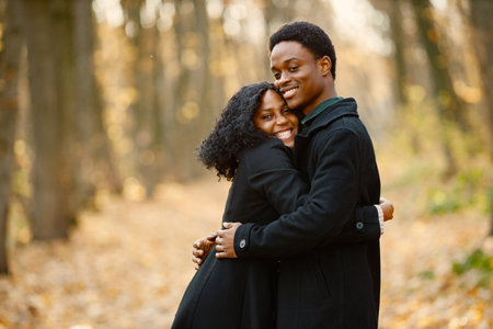Loving black couple walking in park and enjoying autumn dayの写真素材