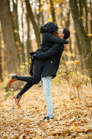 Loving black couple walking in park and enjoying autumn dayの写真素材