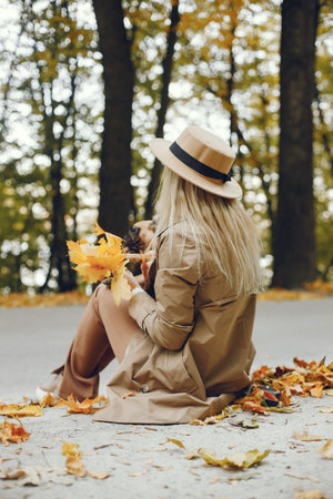 Young blonde girl holding a little puppy french bulldogの写真素材