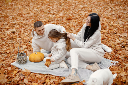 Young family sitting on a blanket in autumn forestの写真素材