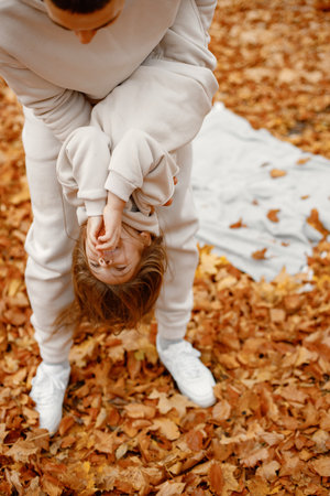 Father with hid daughter playing in autumn forestの写真素材