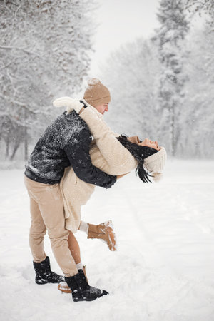 Portrait of romantic couple walking in forest at winter dayの写真素材