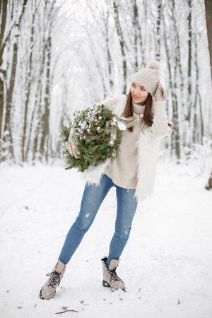 Portrait of a woman standing in winter forest and posing for a photoの写真素材